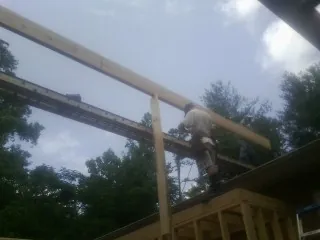 Carpenter setting a ridge beam over a new addition frame — Ice Dam Removal by Roofing Brothers in North Vernon