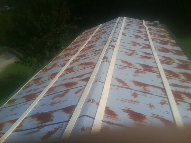 Rusted metal roof panels with new wood purlins before replacement — Storm Damage Roof Repair in North Vernon by Roofing Brothers