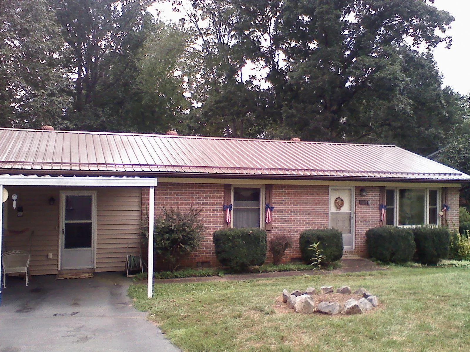 Bronze metal roof and carport on a brick ranch home — Roof Repair work by our crew in North Vernon